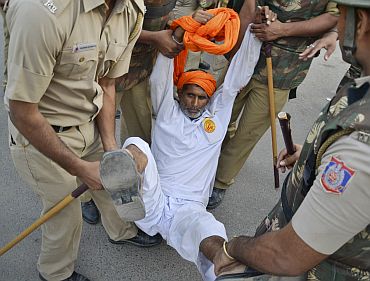 A supporter of yoga guru Ramdev is detained by police at Ramlila grounds in New Delhi
