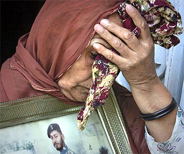 Irshad Bibi grieves with a picture of her son, former navy commando Kamran Ahmed, who was detained in connection with the Mehran attack