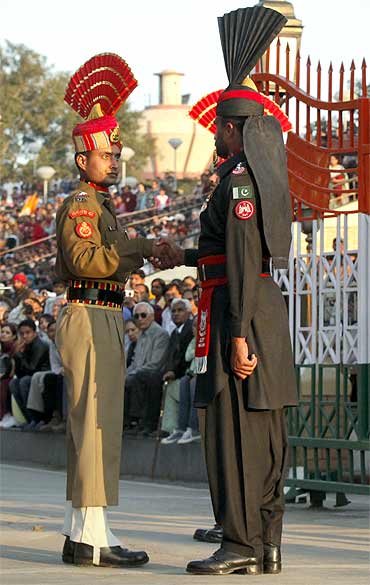 A Pakistani Ranger and an Indian Border Security Force officer shake hands at the Wagah border post