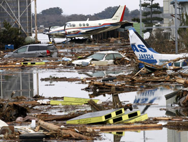 Wreckage of aircraft and cars are seen after being swept by tsunami near Sendai airport