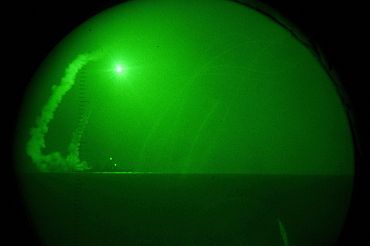 Seen through night-vision lenses, guided missile destroyer USS Barry (DDG 52) fires Tomahawk cruise missiles in support of Operation Odyssey Dawn in the Mediterranean Sea