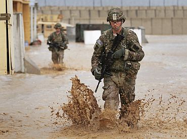 US army soldiers walk through water after a flash floods near Kandahar