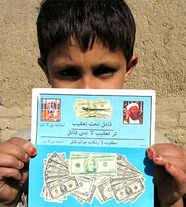 A Pakistani child holds a leaflet offering a multi-million dollar reward for information on Osama bin Laden