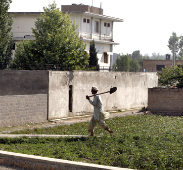 A resident farmer walks past the compound where Al Qaeda leader Osama bin Laden was killed in Abbottabad