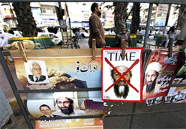 A newspaper stand displays magazines and posters bearing the pictures of Osama bin Laden