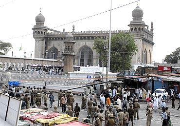 Policemen stand guard at the site of a bomb blast at Mecca Masjid