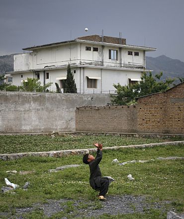 A boy plays with a tennis ball in front of the compound where US Navy SEAL commandos killed Osama bin Laden in Abbottabad