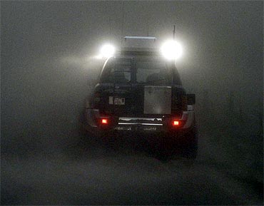 A car is seen through a cloud of ash at the Geirland farm near Kirkjubaejarklaustur
