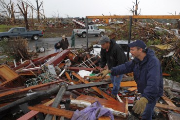 Volunteers look for survivors in the rubble of a home after a devastating tornado hit Joplin