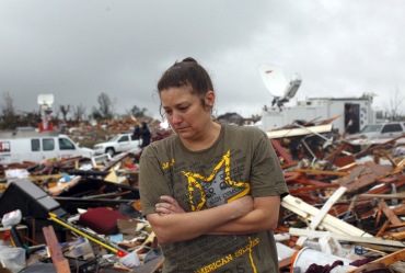 A woman looks through debris