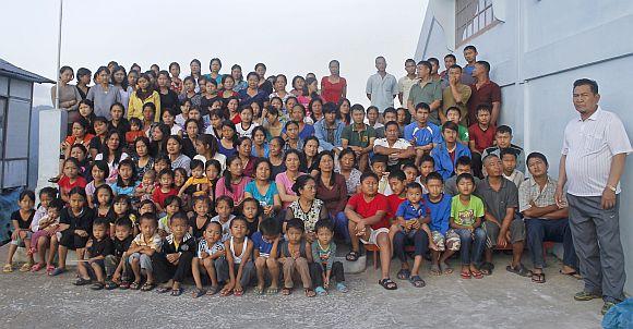 Family members of Ziona (Right) pose for a group photograph outside their residence in Baktawng village in Mizoram