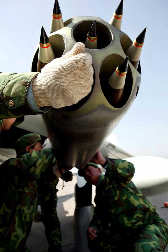 Chinese air force soldiers arm a plane during an exercise at a military base in Jinan