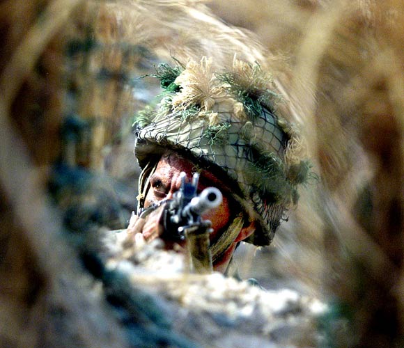 An Indian soldier keeps guard from a bunker, close to the India-Pakistan border, some 52 km from Jammu