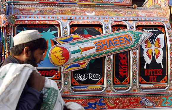 A man walks past a vehicle decorated with an image of a nuclear-capable Shaheen missile in Rawalpindi