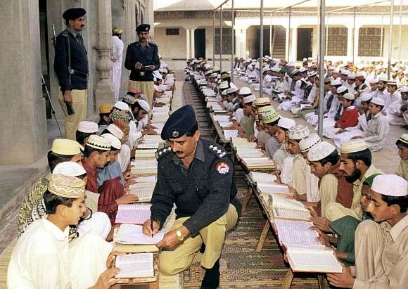 A Pakistan police officer registers student at a religious school in Punjab provincial city of Multan