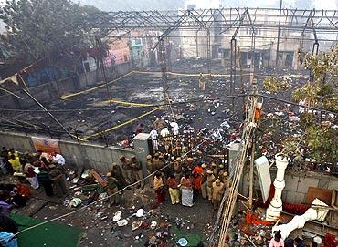 Policemen stand at the gate of a community centre, the site of Sunday's fire which broke out during a congregation of eunuchs, in New Delhi