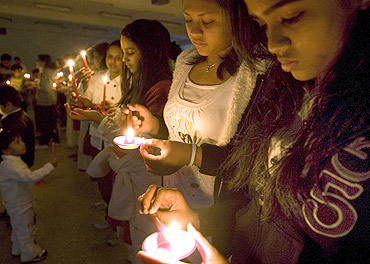 People light candles during a candlelight vigil after 26/11