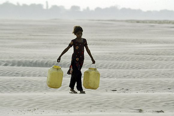 A village girl carries empty containers to collect drinking water near Chilla village in the Bundelkhand region, which may form a separate state carved out of UP