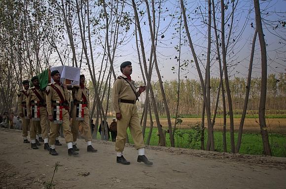 Soldiers carry the flag-draped casket of their colleague who was killed in a NATO cross-border attack one day earlier, to his grave in his hometown of Charsadda in northwest Pakistan