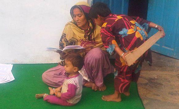 A child peers over to see what her mother is reading