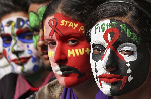 College students pose with HIV/AIDS awareness messages painted on their faces during an awareness campaign in Chandigarh