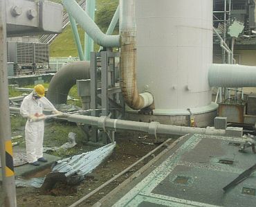 Tokyo Electric Power's handout shows a worker measuring radiation levels at the bottom of a ventilation stack at Fukushima Daiichi nuclear power plant in Japan