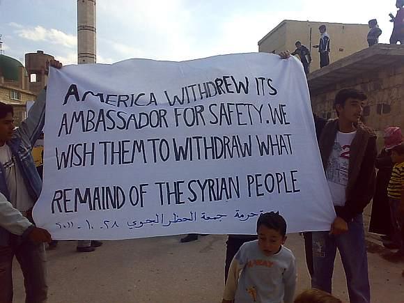 Demonstrators protesting against Syria's President Bashar al-Assad march with a banner through the streets after Friday prayers in Marrat Tahrama near Adlb