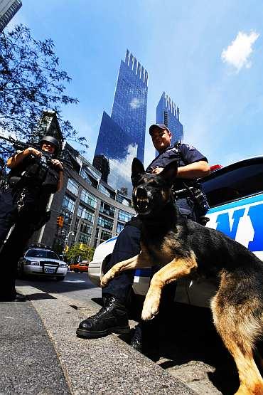 A New York Police Department Hercules team member holds his dog as he patrols near Columbus Circle in New York