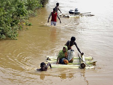 Flood-affected villagers make their way to safer place in Dihasai Biri village