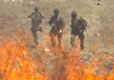 Afghan policemen are seen behind a pile of burning narcotics in Kabul