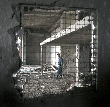 An Afghan policeman inspects a building after a battle with Taliban insurgents near the US embassy