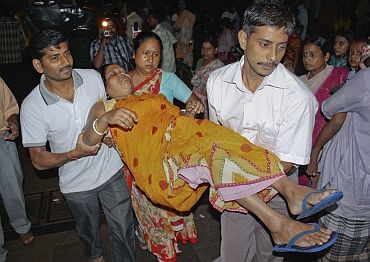 A woman, who was injured by a stampede after an earthquake, is carried to a hospital in Siliguri, West Bengal
