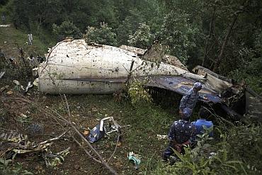 Nepalese police personnel are seen at the crash site of Buddha Air plane in Lalitpur