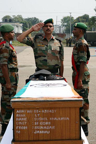 An officer pays his respects to Lieutenant Khajuria