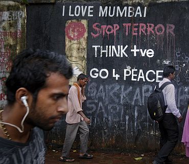 Pedestrians walk past graffiti that outside a Hindu crematorium in Mumbai