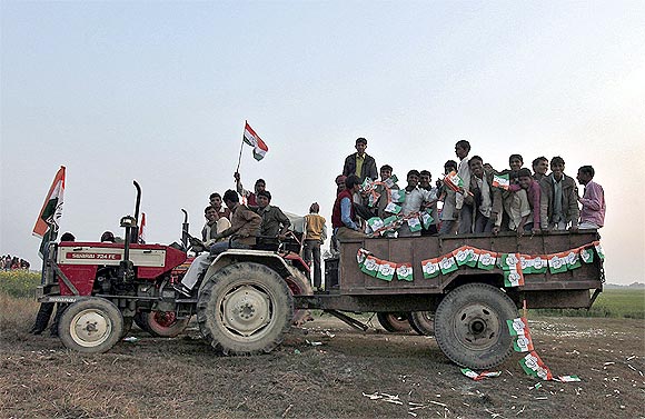 People travel on a tractor after attending an election campaign rally