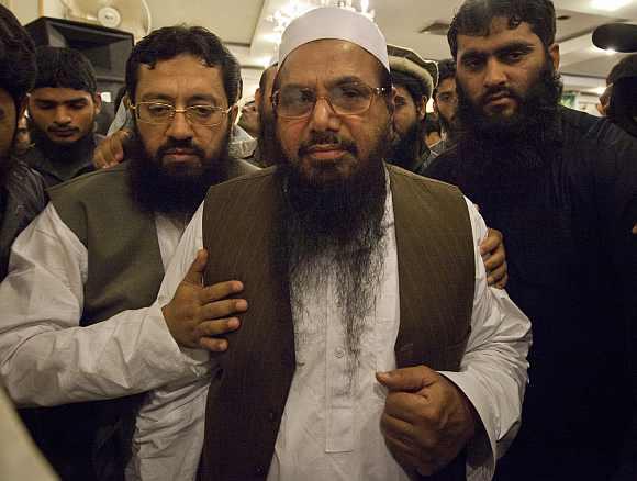 Hafiz Saeed, the head of Jamaat-ud-Dawa and founder of Lashkar-e-Tayyiba, is surrounded by his supporters as he leaves after a news conference in Rawalpindi near Islamabad