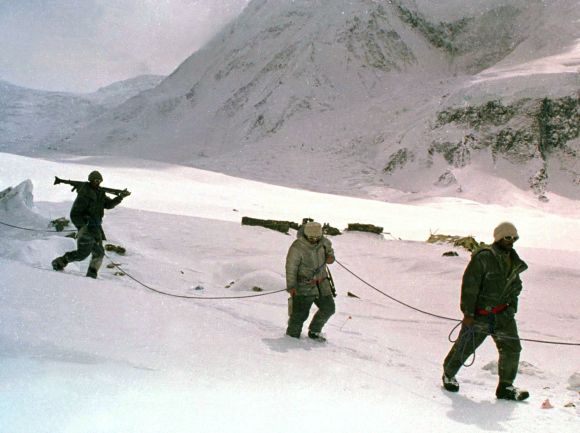 Pakistani soldiers, tied to each other for safety in hostile weather conditions, cross a snowy field on the Siachen Glacier.