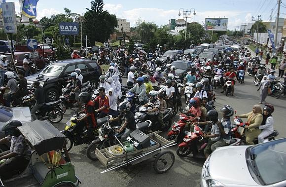 People riding motorbikes and cars packed the street in Banda Aceh after the quake.