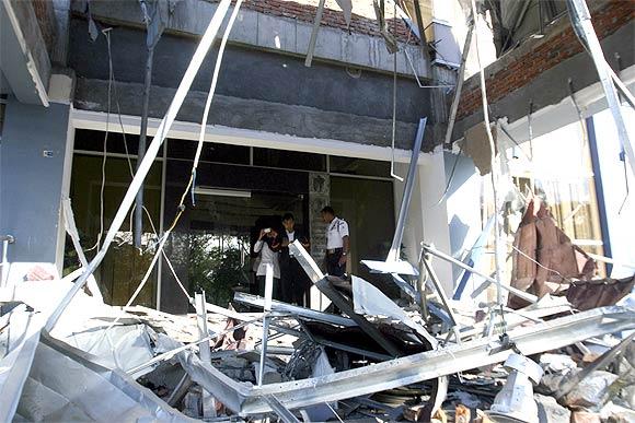 A security guard inspects the damage of a bank office in Indonesia's province of Banda Aceh