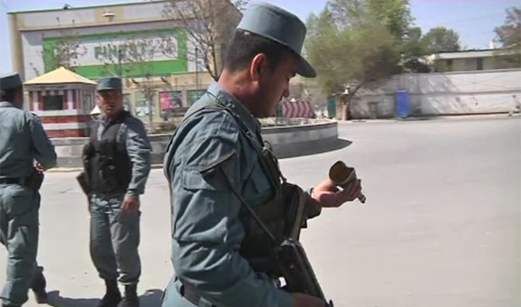 A member of the Afghan security force looks at a piece of debris from a rocket propelled grenade which was found after gunmen launched multiple attacks in Kabul