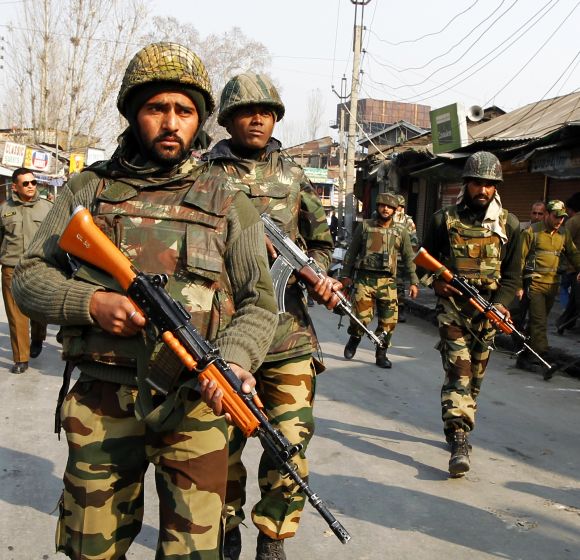 Army soldiers patrol the scene of a shootout in Srinagar