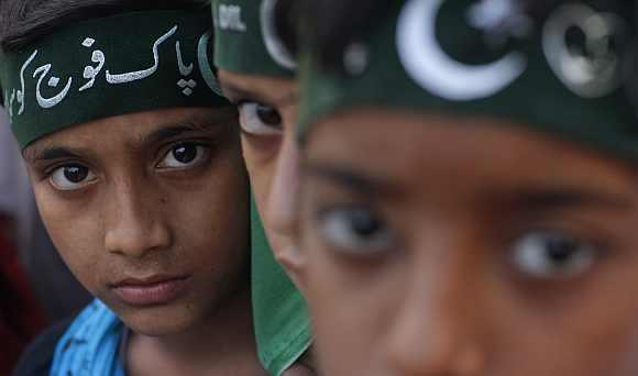 Supporters of the religious political party Sunni Tehreek wear headbands which read in Urdu,Salute to Pakistan army