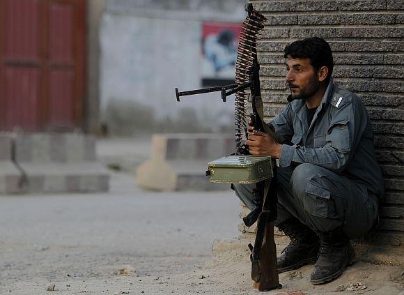 An Afghan policeman keeps guard at the site of an attack in Kabul