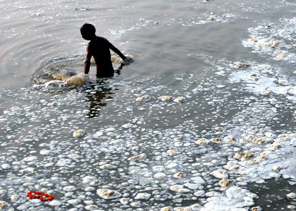 A devotee takes a dip in the polluted Sangam, confluence of three rivers, the Ganga, the Yamuna and Saraswati