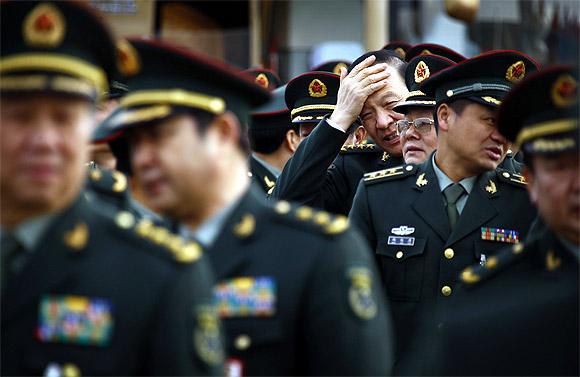 Members of the People's Liberation Army stand together as they arrive at the Great Hall of the People for a session of the National People's Congress, China's annual parliament, in Beijing