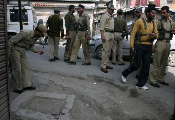 Senior police officers inspect the spot where assistant sub-inspector Sukh Pal Singh was shot