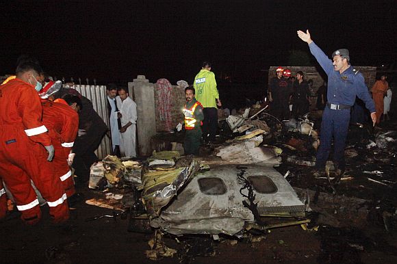 Police and rescue workers go through the wreckage