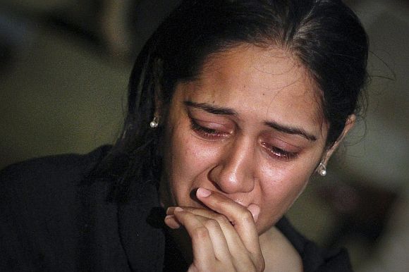 A relative of a victim of the Bhoja Air airliner crash mourns at the Jinnah International Airport