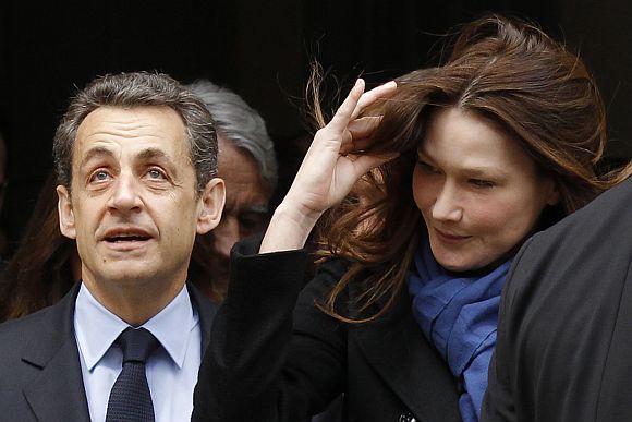 France's President Sarkozy leaves a polling station with his wife Carla Bruni-Sarkozy after voting during the first round of 2012 French presidential election in Paris
